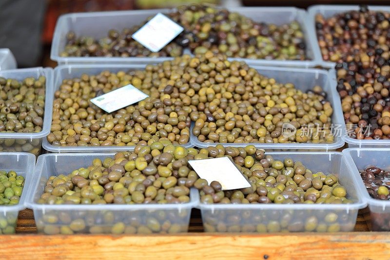 Pazari i Ri-New Bazaar的一个市场摊位上，塑料盒子里装着餐桌上的橄榄——大部分是绿色的。地拉那-阿尔巴尼亚- 001